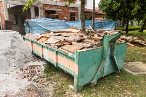 Team member clearing a residential garden in Kenton, showing tools and safety equipment